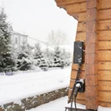 Wallbox Besen BN30 zamontowany na zewnątrz w zimie Wallbox 22 kW Besen BN30 zamontowany na drewnianej ścianie domu pokryty śniegiem, odporny na mróz i wilgoć