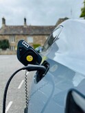 Kabel do ładowania samochodu elektrycznego 22 kW Typ 2 - ładowanie przy publicznej stacji AC Kabel Typ 2 do ładowania samochodu elektrycznego 22 kW podłączony do auta przy parkingu - złącze żeńskie Typ 2 wpięte w gniazdo ładowania pojazdu elektrycznego